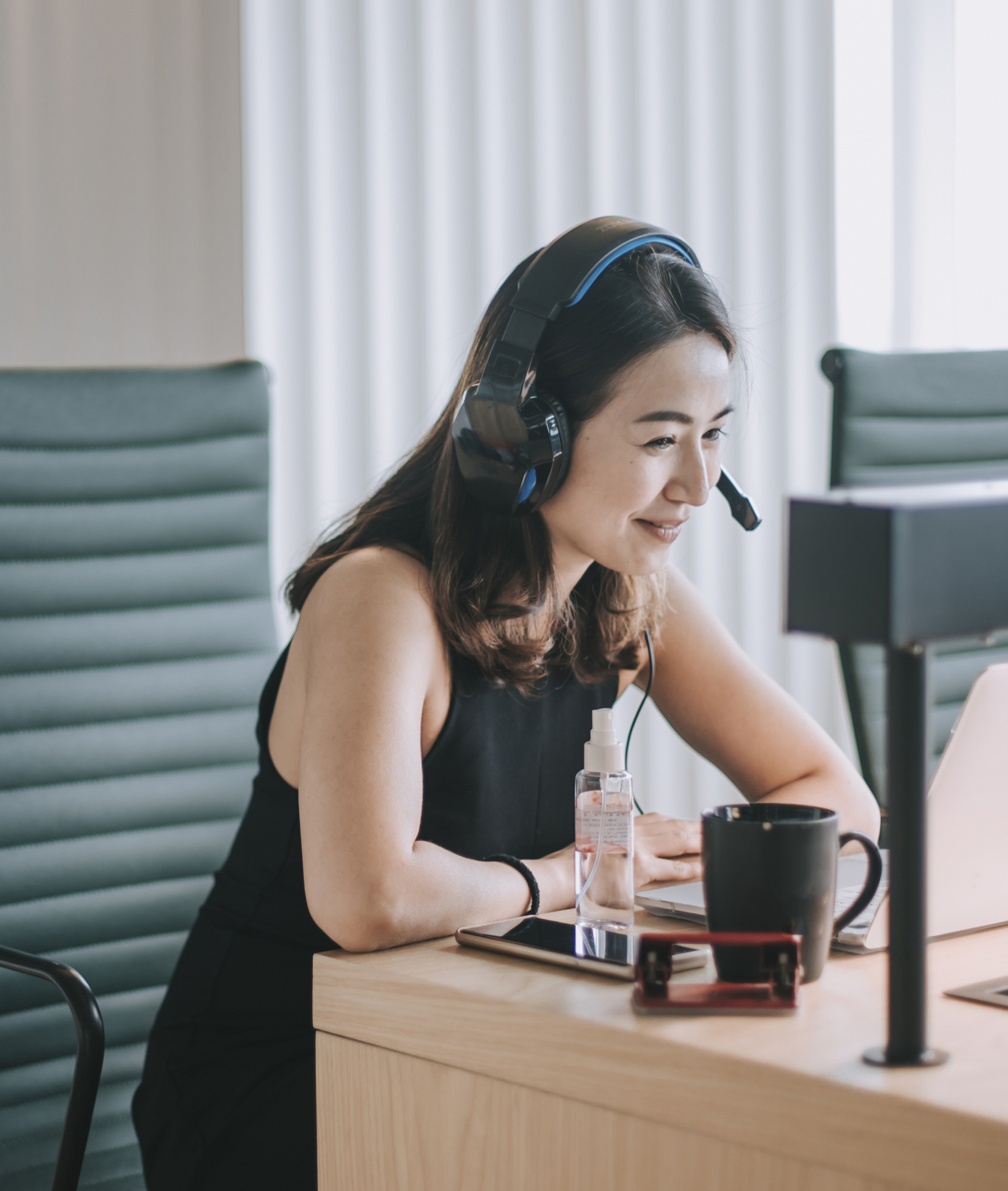 an asian chinese beautiful woman white collar worker talking to the camera video calling video conference with his business partners with face mask